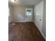 Empty room with neutral walls, front door, and wood-look flooring at 5157 West St, Covington, GA 30014