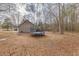 Expansive backyard with a trampoline, wooded area, and house with neutral siding at 5833 Westerling Pl, Powder Springs, GA 30127