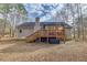 Backyard of a beige house featuring a covered porch and a wooden deck at 5833 Westerling Pl, Powder Springs, GA 30127