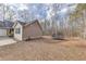 Backyard featuring a trampoline, wooded area, and attached garage with neutral siding at 5833 Westerling Pl, Powder Springs, GA 30127