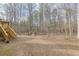 Spacious backyard featuring a wooded lot and a staircase leading to a deck at 5833 Westerling Pl, Powder Springs, GA 30127