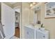 Bathroom featuring a vanity with sink, a large mirror, and a doorway to another room at 5833 Westerling Pl, Powder Springs, GA 30127