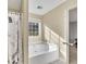 Bright bathroom featuring a soaking tub with a large window and an Eiffel Tower shower curtain at 5833 Westerling Pl, Powder Springs, GA 30127