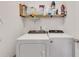 Functional laundry area with modern appliances and shelving for storage at 5833 Westerling Pl, Powder Springs, GA 30127