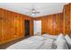 Bedroom featuring wood paneling, white bedding, and contrasting dark doors at 645 Cumberland Rd, Atlanta, GA 30306