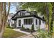 Charming home exterior with a rooftop deck, manicured landscaping, and modern black and white design at 645 Cumberland Rd, Atlanta, GA 30306