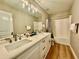 Bathroom features double sink vanity, tub and shower, and wood-look flooring at 91 Reynoldston Ct, Suwanee, GA 30024