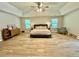 Spacious main bedroom with wood floors, ceiling fan and sitting area at 91 Reynoldston Ct, Suwanee, GA 30024