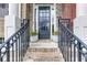 Inviting front entrance with brick steps, iron railings, and a black front door creating a welcoming entry point to the home at 5964 Reddington Way, Sandy Springs, GA 30328