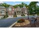 Street view of the brick townhomes surrounded by mature trees, benches and manicured landscaping, creating a serene and inviting atmosphere at 5964 Reddington Way, Sandy Springs, GA 30328