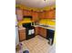 A well maintained kitchen features yellow walls and wooden cabinetry and black appliances at 6424 W Charter Way, Lithonia, GA 30058