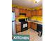 A well maintained kitchen features yellow walls and wooden cabinetry and black appliances at 6424 W Charter Way, Lithonia, GA 30058