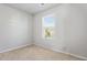 Carpeted bedroom with a large window and neutral walls at 11997 Lovejoy Crossing Way, Hampton, GA 30228