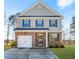 Two-story home with a brick facade, gray siding, black shutters, and an attached garage at 11997 Lovejoy Crossing Way, Hampton, GA 30228