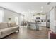 Open-concept living room with kitchen and dining area, featuring modern finishes and natural light at 11997 Lovejoy Crossing Way, Hampton, GA 30228