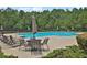 Community swimming pool featuring lounge chairs and tables under sun umbrellas surrounded by a wood line at 48 Scenic Ovlk, Acworth, GA 30101