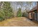 A spacious backyard with a brick wall, green grass, trees, and fencing at 1605 Saint Tropez Way, Atlanta, GA 30350