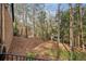 Backyard featuring a brick retaining wall and a downward slope covered in trees and foliage at 1605 Saint Tropez Way, Atlanta, GA 30350