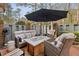 An outdoor seating area under an umbrella, with comfortable seating and views of the backyard at 1605 Saint Tropez Way, Atlanta, GA 30350