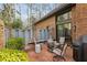 Outdoor patio area with seating, fire pit, and string lights surrounded by a brick fence at 1605 Saint Tropez Way, Atlanta, GA 30350