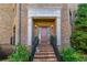 Brick townhome showcasing a stone front porch with railing and manicured landscaping at 3631 Habersham Nw Rd, Atlanta, GA 30305