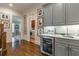 Hallway with hardwood floors and a wet bar featuring grey cabinets and a wine fridge at 3631 Habersham Nw Rd, Atlanta, GA 30305