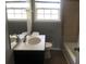 Bright bathroom featuring a vanity, toilet, tub, and window that provides natural light at 5250 Hollyhock Rd, Douglasville, GA 30135