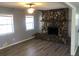 Cozy living room with a stone fireplace, ceiling fan, new floors, and large windows at 5250 Hollyhock Rd, Douglasville, GA 30135