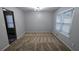 Neutral carpeted dining area featuring modern lighting, large windows, and gray walls with ample space at 3515 Weathered Wood Dr, Ellenwood, GA 30294