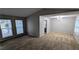 Neutral carpeted dining area featuring modern lighting, large windows, and gray walls with ample space at 3515 Weathered Wood Dr, Ellenwood, GA 30294