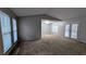 Bright living room featuring large windows, neutral carpet, and gray walls with ample space for furniture at 3515 Weathered Wood Dr, Ellenwood, GA 30294