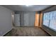 Carpeted main bedroom with ample closet space and a window offering views at 3515 Weathered Wood Dr, Ellenwood, GA 30294