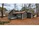 Charming home exterior featuring a deck, gray siding, and a backdrop of mature trees at 3515 Weathered Wood Dr, Ellenwood, GA 30294