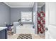 Bright bathroom featuring a tub under a window and a shower with patterned curtains at 5806 Highgrove Dr, Atlanta, GA 30349