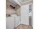Functional laundry room with a washer, dryer, and shelving for storage, next to a bedroom at 5806 Highgrove Dr, Atlanta, GA 30349