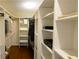Organized walk-in closet with white shelving and wood floors for ample storage at 1104 Fox Ln, Woodstock, GA 30188