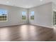 Bright and open living room featuring hardwood floors, large windows, and neutral paint for versatile design options at 1261 Burlington Ct, Mcdonough, GA 30253