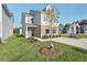 New two-story home featuring gray siding, brick accents, and a freshly landscaped yard with young trees at 2015 Wyndham Pl, Conyers, GA 30013