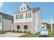 New construction home featuring gray siding, brick accents, and landscaped yard at 2015 Wyndham Pl, Conyers, GA 30013