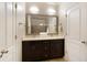 Bright bathroom with double vanity, a large framed mirror, dark cabinets, and tile flooring at 1365 Hawthorne Se Ave, Smyrna, GA 30080