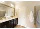 Bathroom featuring double vanity, dark cabinets, framed mirror, and tile flooring adjacent to walk-in shower at 1365 Hawthorne Se Ave, Smyrna, GA 30080