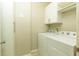 Clean laundry room equipped with washer, dryer, and upper cabinets for organized storage at 1365 Hawthorne Se Ave, Smyrna, GA 30080