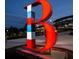 Oversized red sign featuring a baseball 'B' and an illuminated baseball stadium in the background at 1365 Hawthorne Se Ave, Smyrna, GA 30080