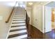 Elegant staircase featuring hardwood steps, iron balusters, and natural light streaming through an open doorway at 1365 Hawthorne Se Ave, Smyrna, GA 30080