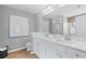 Well-lit bathroom with dual vanities, wood-look flooring, and shower at 309 Heavenly Hollow Pl, Mcdonough, GA 30253