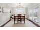 Cozy dining area with natural light, featuring a modern chandelier, wooden table, and access to outdoor space at 174 Kelly St, Norcross, GA 30071