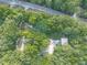 Aerial view of the property showing the house and surrounding mature trees next to a road at 4422 Fincher Rd, Canton, GA 30114