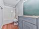 Bathroom featuring blue cabinets, wood-look floors, and a shower-tub combo at 4422 Fincher Rd, Canton, GA 30114