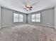 Carpeted bedroom featuring a ceiling fan, neutral walls, and two bright windows at 4422 Fincher Rd, Canton, GA 30114