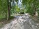 Split gravel driveway leading to a secluded home nestled among mature trees at 4422 Fincher Rd, Canton, GA 30114